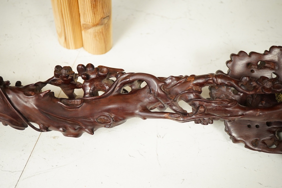 A Chinese carved hardwood Ruyi sceptre, with two porcelain ‘dragon’ beads, 50cm in length